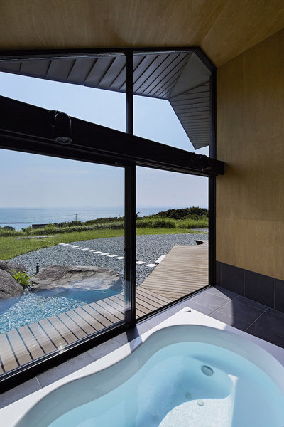 Dans la salle de bains, ouverte par une large baie vitrée, l’ambiance zen est totale. A l’extérieur, le bois, la pierre et le végétal sont les éléments constituant de la nature. Un concept récurant dans l’architecture japonaise.