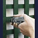 Etape 3 : Posez les montants sur le mur et, à l’aide de votre Dremel 150 3,2 mm et du jeu de forets de précision 628, percez un trou dans le treillis et le montant et jusqu’arriver dans le mur de votre cour. Ainsi, vos plantes auront de l’espace pour grimper derrière le treillis et s’y enchevêtrer. Ici, le treillis est posé à l’envers, côté rectiligne vers le haut et côté cintré vers le bas. Si vous procédez ainsi, vous devrez teinter le rebord supérieur de votre treillis pour l’harmoniser avec l’ensemble.