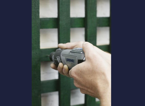 Etape 3 : Posez les montants sur le mur et, à l’aide de votre Dremel 150 3,2 mm et du jeu de forets de précision 628, percez un trou dans le treillis et le montant et jusqu’arriver dans le mur de votre cour. Ainsi, vos plantes auront de l’espace pour grimper derrière le treillis et s’y enchevêtrer. Ici, le treillis est posé à l’envers, côté rectiligne vers le haut et côté cintré vers le bas. Si vous procédez ainsi, vous devrez teinter le rebord supérieur de votre treillis pour l’harmoniser avec l’ensemble.