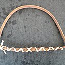 L'osier est assoupli, coupé, désépaissi et maintenu en arc de cercle par une lanière d'osier.