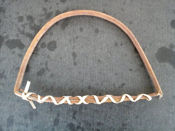 L'osier est assoupli, coupé, désépaissi et maintenu en arc de cercle par une lanière d'osier.