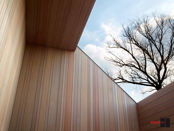Le bardage extérieur en Afrormosia, bois africain durable proche du teck, a été posé à la verticale. Au fil du temps, il offrira une patine plus homogène, car il est orienté dans le sens de la pluie. Ses lames de largeurs variables créent un jeu graphique de rayures qui brise la monotonie des revêtements classiques. Gros-œuvre fermé (panneau): Vermeersch Bart. Zinc : Moerkerke Dakwerken bvba, Wevelgem.