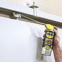 Lubrification d'un rail de porte coulissante avec la Graisse en Spray WD-40.