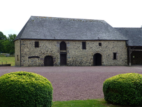 Exemple de maison ancienne avec un premier plan fait de buis taillés en rond. Atout-charme et nature !