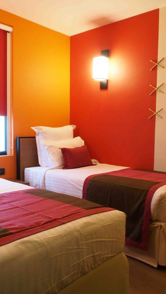 Sur les lits, les assemblages de tissus font écho aux traditions textiles populaires de patchwork revues ici sur un mode plus actuel et graphique.