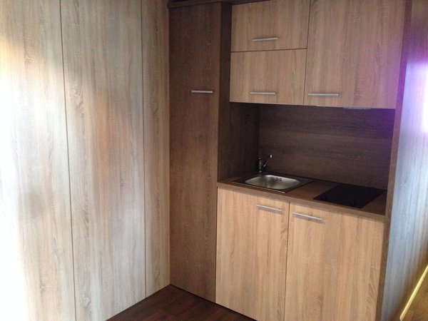 Le Kub dans sa configuration meublée, vous offre une cuisine aménagée en bois. Idéal pour en faire un petit studio indépendant.