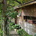 La roseraie en arceaux de bois de lamellé collé abritant la petite brocante de la Grenouillère.