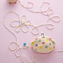 Pochette en coton perlé, rehaussé de perles formant des pois multicolores.