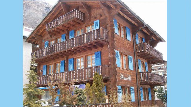 Chalet de Zermatt « les Narcisses ». Le bois est teinté par le temps, ce sont les volets bleus clairs qui donnent tout le charme à ce chalet.