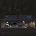 Le soir, la baie vitrée laisse entrevoir la pièce à vivre, avec le séjour et la cuisine ouverte. En mezzanine, la chambre et la salle de bains.