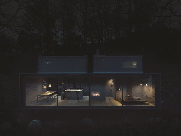 Le soir, la baie vitrée laisse entrevoir la pièce à vivre, avec le séjour et la cuisine ouverte. En mezzanine, la chambre et la salle de bains.