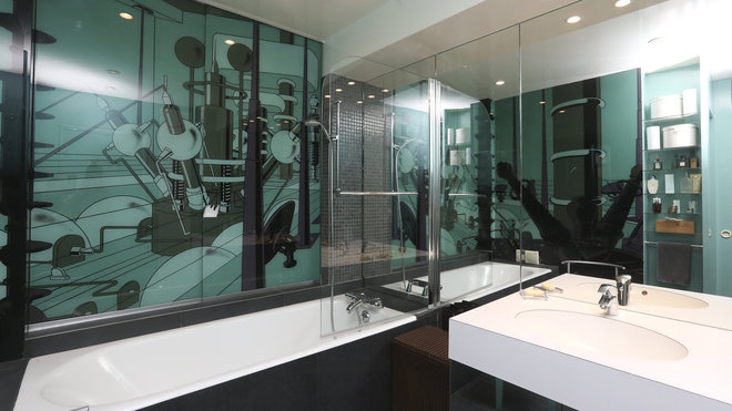 La salle de bains s’offre un œuvre murale résolument contemporaine.