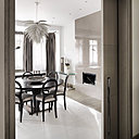 La porte coulissante qui permet d’accéder à la salle à manger disparait dans la double cloison. Suspension lumineuse « Aloe Blossom » by Jeremy Cole.