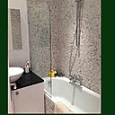 Avant, une salle de bains démodée et sans buanderie. Après, un espace dédié au plaisir du bain encadré par une mosaïque à effets de galets. Un espace dédié à la buanderie ayant été créé à part.