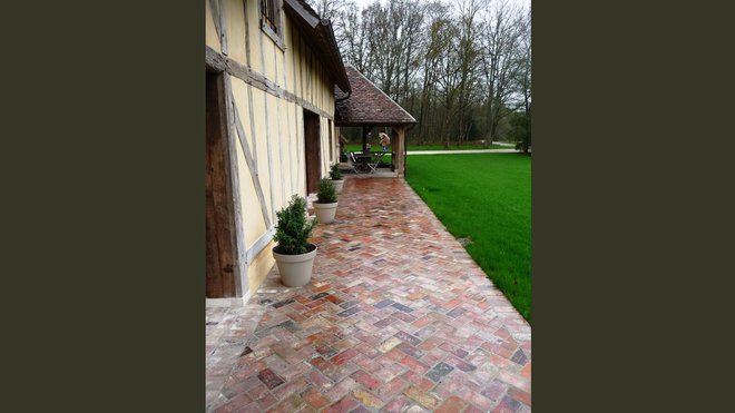 Terrasse réalisée avec des briques anciennes de récupération (format : 5 x 11 x 22 cm), chez Vestiges de France.