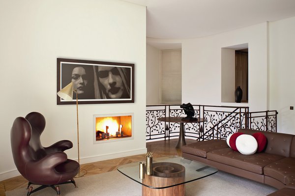 L’étage du duplex se veut plus cosy, avec son canapé en cuir marron, ses petites touches de bordeaux. La décoration est minimaliste, laissant les matériaux parler d’eux-mêmes.