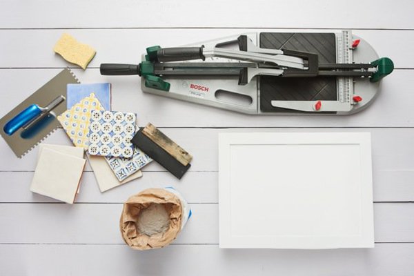 Le matériel qu'il vous faut : coupe carrelage Bosch PTC 470, des carreaux, du ciment colle, du joint, un platoir, une éponge.