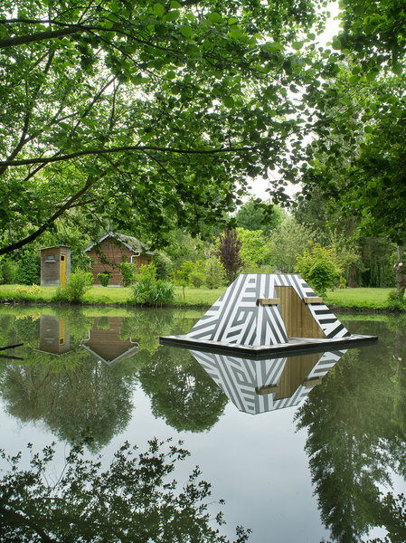 Dazzle Gabion de Jeanne Tzaut est un trompe l’oeil sur plate forme flottante, à la fois militaire et esthétique il se refléte dans le rieu.