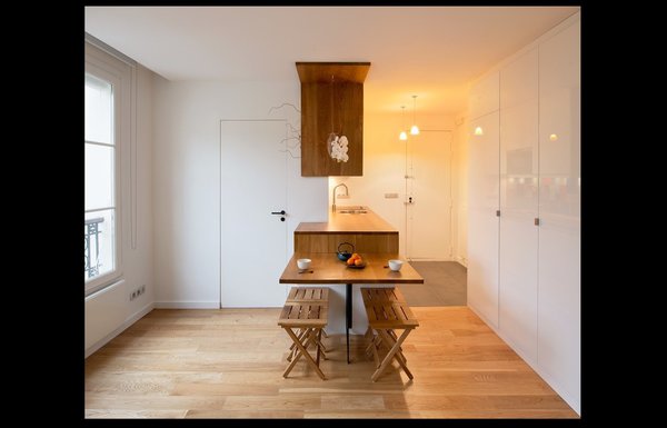 Un vase suspendu, mis en valeur par l’habillage en chêne massif qui lui sert de cadre permet de composer un bouquet aérien sans encombrer le plan de travail et la table.