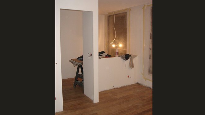 Travaux : montage du mur de la chambre qui offrira une partie vitrée transparente et des parties totalement opaques pour le lit et le bureau.