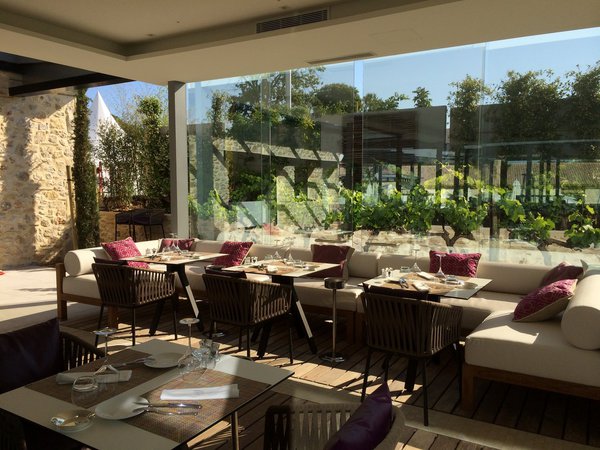 Effet « dedans-dehors » à l’heure des repas avec des banquettes confortables et du mobilier en corde tressée.