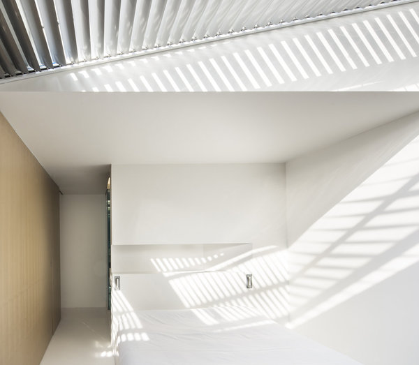 Les stores à lames métalliques dessinent un esprit de « lumière ligne » géométrisée, qui crée un décor d’ombres. Ce décor mouvant habille les espaces de détente, comme le séjour et la chambre.