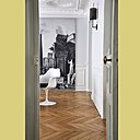 Un tissu tendu sur un cadre accentue la perspective de la salle à manger lorsqu’on y accède par le couloir. Le motif panoramique, issu de documents anciens représentant une fantaisie architecturale, a été recomposé par le créateur Christian Lacroix (Christian Lacroix by Designers Guild).