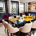 Des tables en émail coloré meublent la salle de petit-déjeuner.