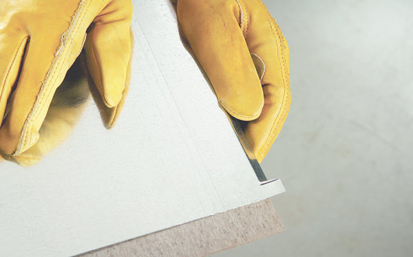 Etape 4 : En vous guidant avec le bord de votre surface de travail, pliez 3 côtés de 1 cm de ce revêtement pour votre solarium.