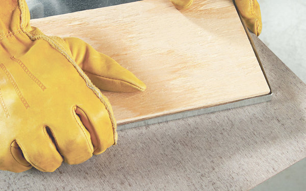 Etape 5 : insérez une petite pièce de bois à l’intérieur de la feuille métallique pour vous aider à réaliser la dernière pliure. Disposez votre feuille de revêtement métallique dans le plateau en bois. Ajoutez des plantes dans des pots en terre cuite et de l’eau.