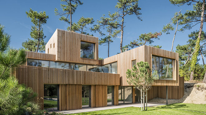 Près des plages basques, cette résidence aux volumes cubiques emboités s'insère dans une pinède. Elle est bardée de fins linteaux de Red Cedar qui rappellent les grands arbres environnants. Réalisation Atelier Delphine Carrère.