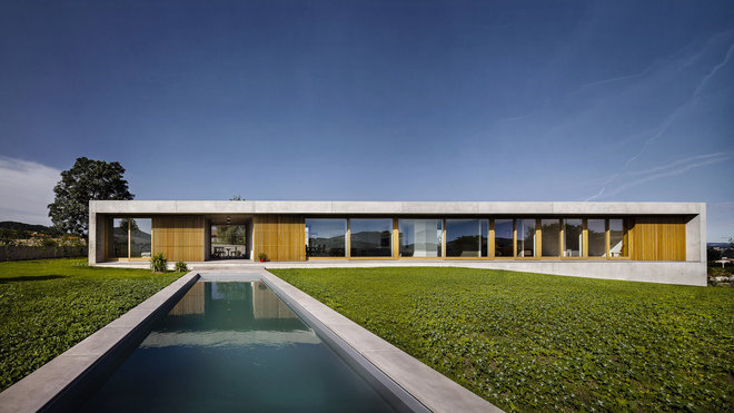 Comme une ligne forte à laquelle répond une grande piscine placée à la perpendiculaire, dans l'axe de l'entrée, la maison horizon est abritée par un cadre de béton brut étiré dans le paysage. Réalisation DDA.