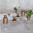 Elégant, un vase bouteille en verre transparent et cuivré. Existe en plusieurs dimensions. H 25 x diamètre 15 cm et H 28 cm x diamètre 13 cm. Prix sur demande. Vase bouteille Gold Girogio. Maison Aimable.