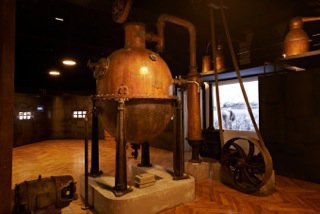 Alambics et cuves de macérations datant de la fin du XIXème siècle rappellent les différentes étapes de la fabrication, notamment la distillation et la macération.