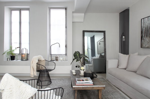 Le salon décline les gris jusqu’au noir sur la toile de fond blanche des murs.