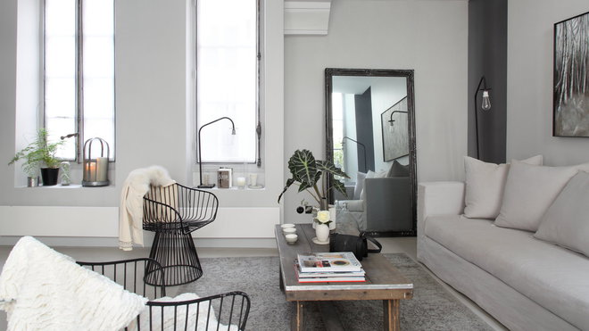 Le salon décline les gris jusqu’au noir sur la toile de fond blanche des murs.