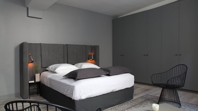 Dans la chambre, une tête de lit recouverte de tweed dessine un paravent. Les placards totalisent 25 mètres de dressing.