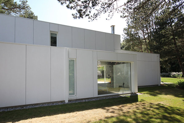Derrière les espaces de vie ouverts sur le jardin, se cachent dans un écrin blanc et opaque, l’arrière cuisine et un garage.