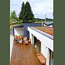 La terrasse de 100 m² prolonge la grande pièce à vivre. Un préau se dessine aux beaux jours grâce à un système de baies coulissantes.