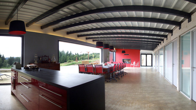 Le corps central de la maison est composé d’un espace entièrement décloisonné. Seul le mobilier distingue la cuisine de la salle à manger et du salon. Les espaces privés des trois générations d’occupants s’organisent autour de ce grand espace de vie mi-intérieur, mi-extérieur, avec escalier double.