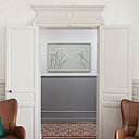 Dans le salon, les éléments d’architecture intérieure et les boiseries ont été mis en valeur par des teintes douces grises et beiges qui contrastent avec les carreaux de ciment du sol de l’entrée. Fauteuils Butterfly Wing Chair en cuir et Lloyd Loom (papier tressé autour d’une armature en fil métallique), Vincent Sheppard.