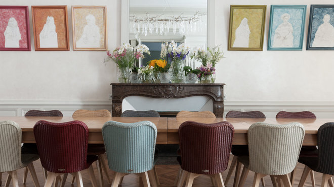 Table en tilleul fabriquée par un artisan breton. Chaises Lily en Lloyd Loom (papier torsadé autour d’un fil d’acier), Vincent Sheppard. Elles ont été repeintes et customisées par Lise Humeau. Galerie de portraits des ancêtres, créations de Lise Humeau.