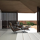 Dans le salon, le sol est recouvert d’un calepinage de pierres de grand format au doux ton de sable. Les murs et les plafonds sont peints en blanc. Les zones d’ombre sont recouvertes de panneaux de bois d'iroko.