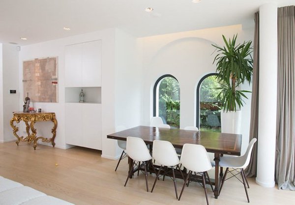 La salle à manger est éclairée par des fenêtres avec châssis aluminium en partie cintrés.