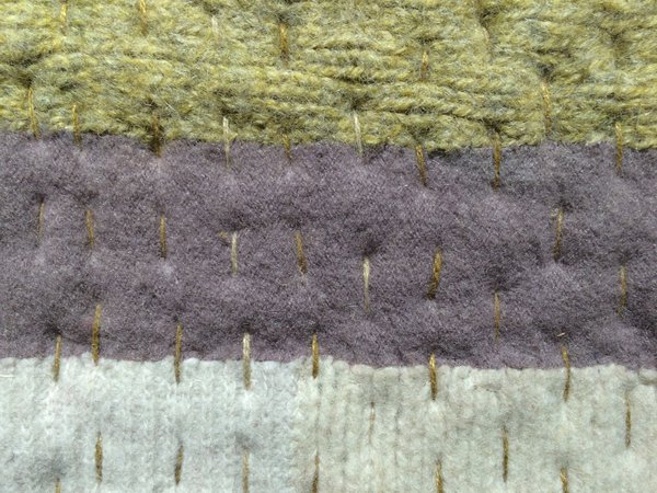 Aquarelle est constitué de plusieurs champs de couleur, montés en rayures et carreaux réalisée à partir de morceaux irréguliers de pulls en laine, les couches sont cousues au point de piqûre puis mis en place à l'aide de point longs et droits.