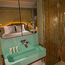 Douche tapissée de pâtes de verre irisée or et touche de bleu turquoise, dans la chambre Lady Soul dorée.