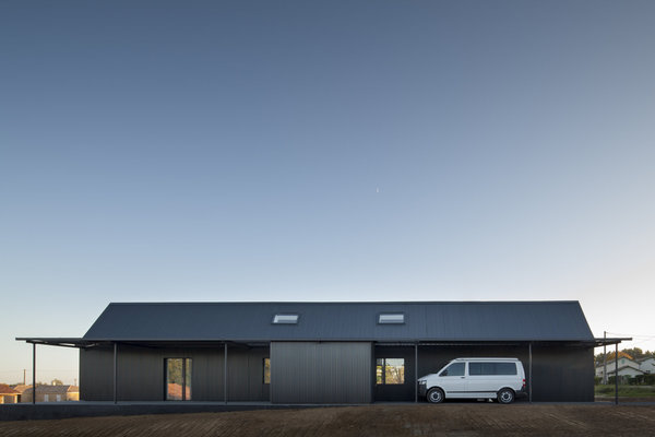 L’auvent est prolongé au droit du mur permettant d’abriter le véhicule, et de créer en outre un porche. A cet endroit, des gravillons noirs remplacent le carrelage extérieur.