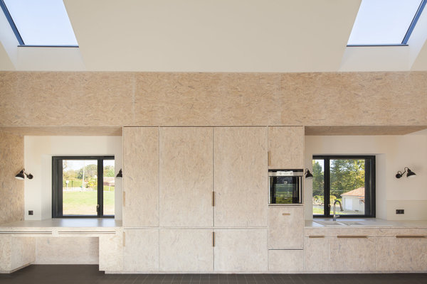 La vaste pièce à vivre a été habillée d’une cuisine sur mesure qui recouvre tout un mur. Deux puits de lumière, l’un au-dessus du plan de travail de la cuisine, l’autre au-dessus du bureau, viennent compléter l’éclairage latéral.