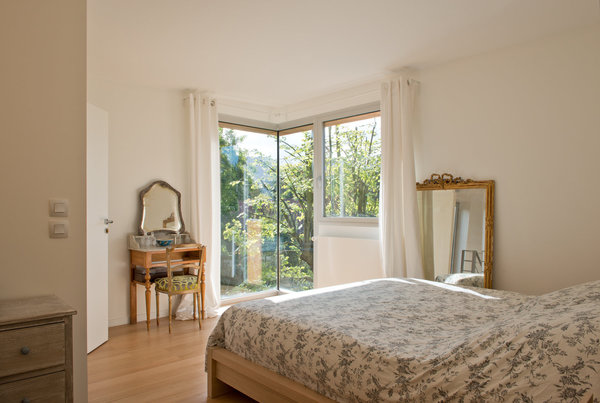 La chambre parentale domine le jardin et s’ouvre sur l’extérieur par une grande baie d’angle.