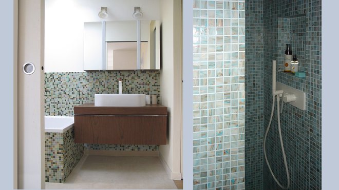 La mosaïque de la salle de bains parentale dans les tons vert, brun et miel renvoie aux couleurs de la végétation extérieure. La pièce est éclairée par une large ouverture zénithale, tandis qu’une fenêtre en hauteur laisse entrer la nature dans la pièce.